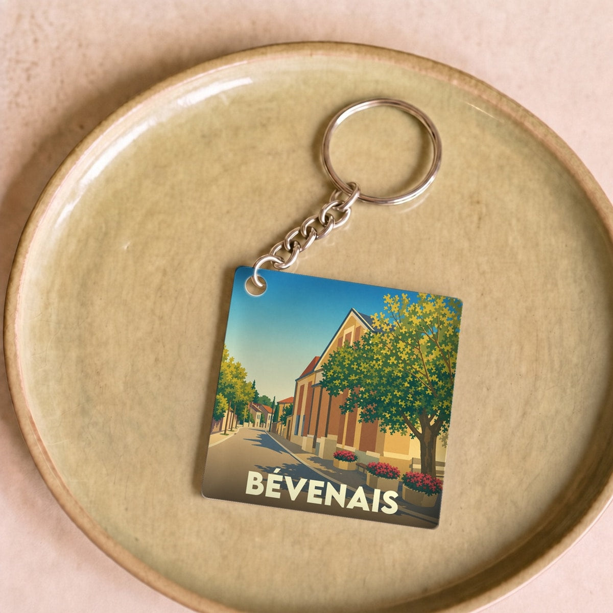 Porte-clés souvenir de la ville de Bévenais avec une illustration stylisée.