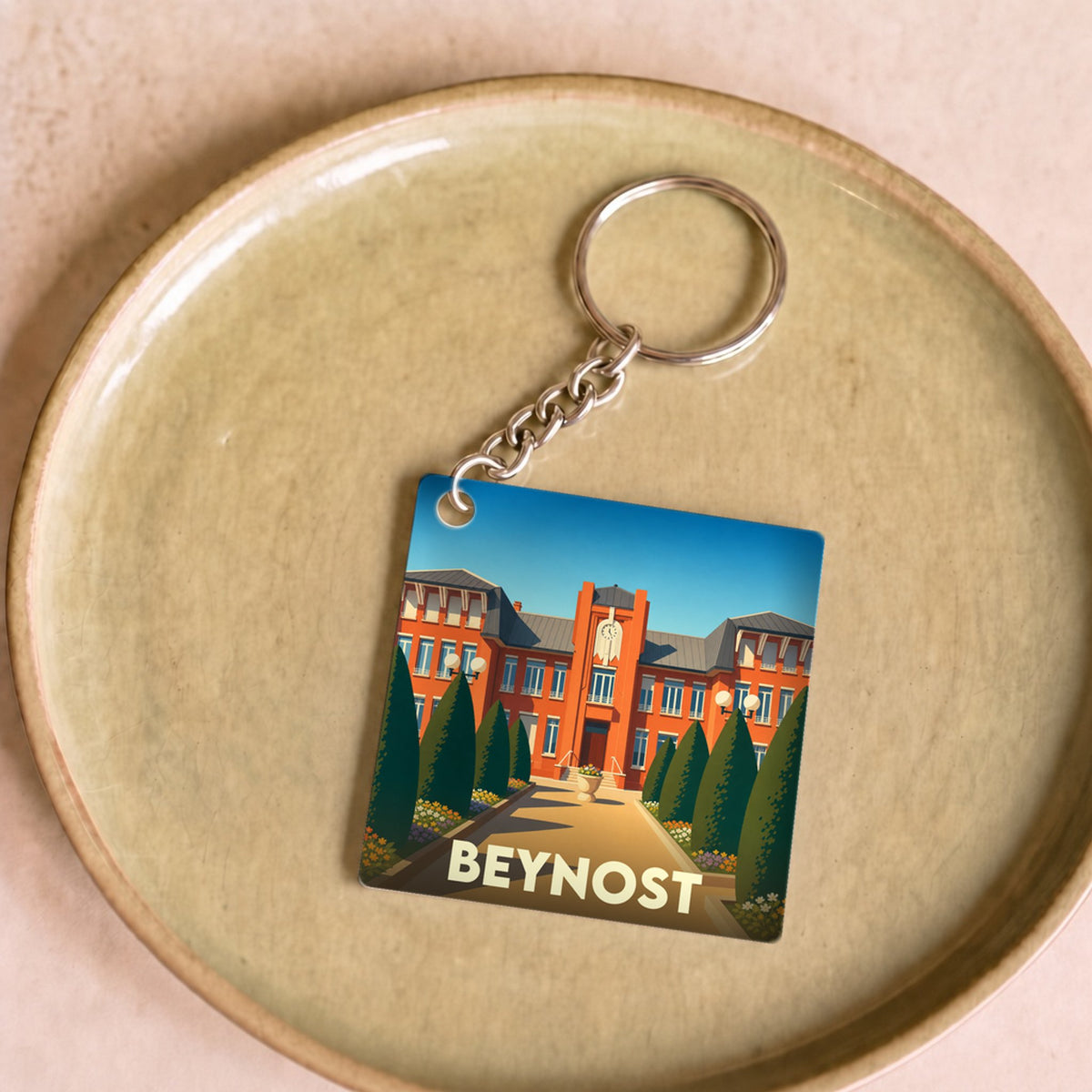 Porte-clés souvenir de la ville de Beynost avec une illustration stylisée.