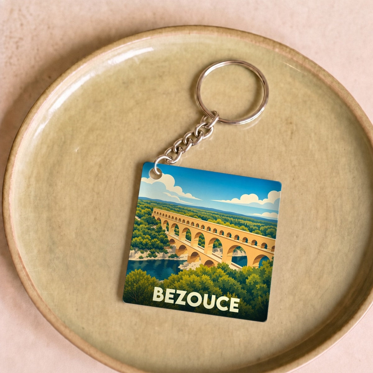 Porte-clés souvenir de la ville de Bezouce avec une illustration stylisée du Pont du Gard.