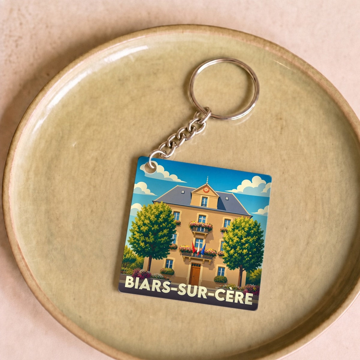 Porte-clés souvenir de la ville de Biars-sur-Cère avec une illustration stylisée de la mairie.