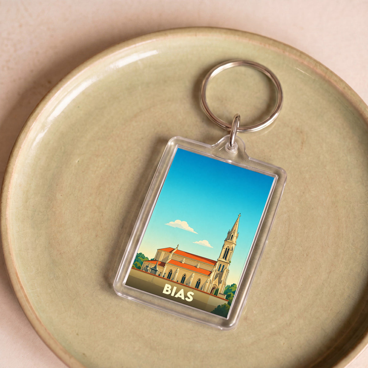 Porte-clés souvenir de la ville de Bias avec une illustration stylisée de son église.