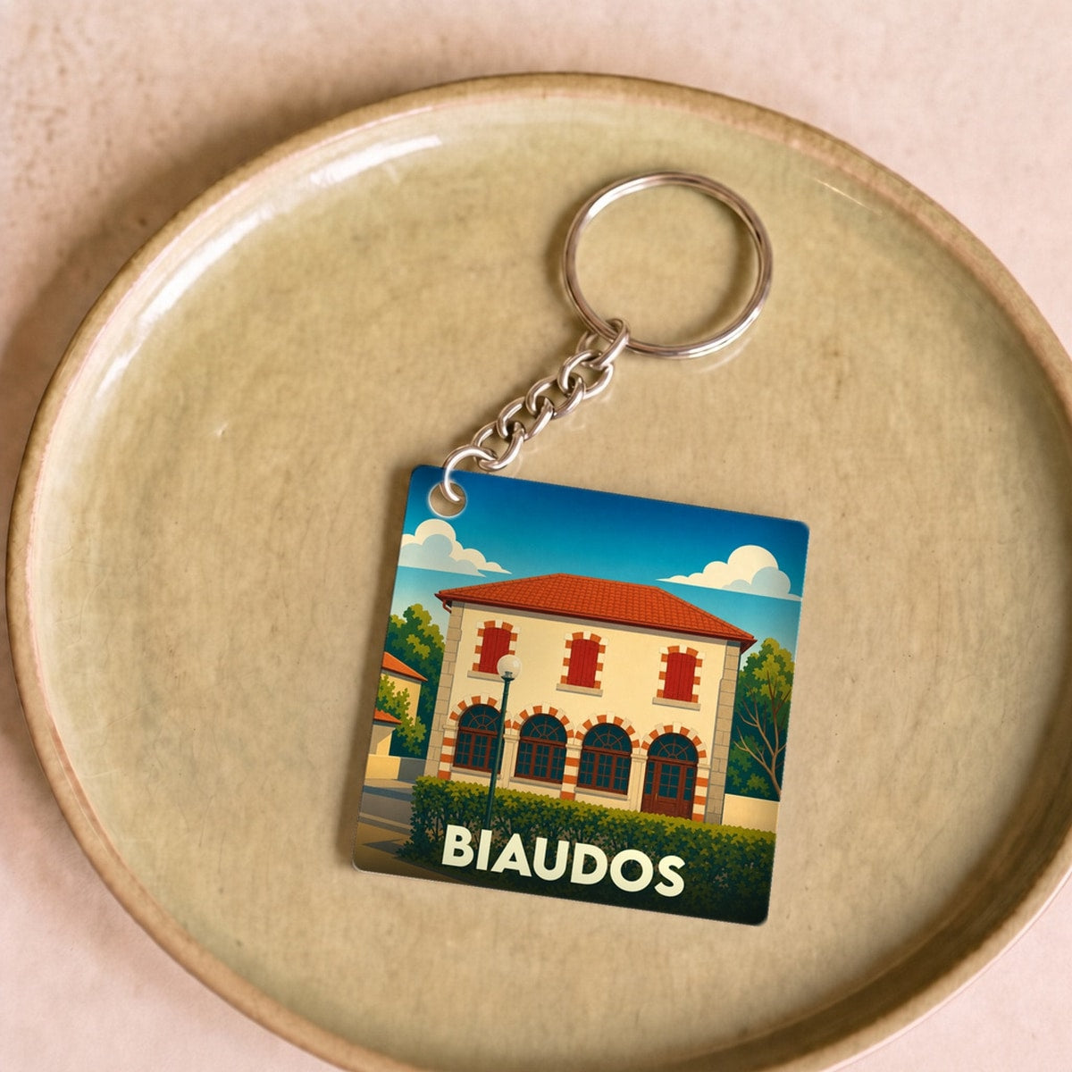 Porte-clés souvenir de la ville de Biaudos avec une illustration stylisée.