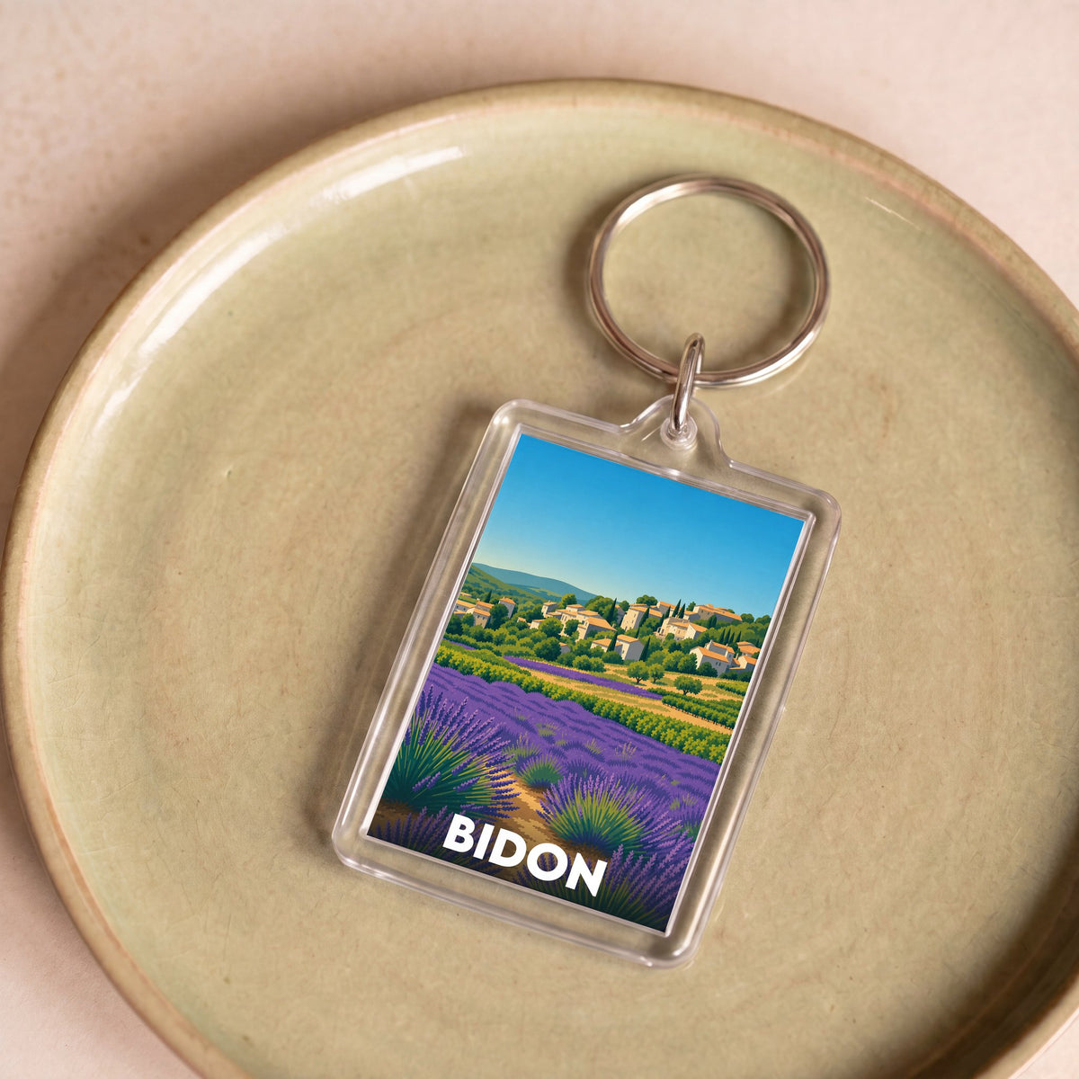 Porte-clés souvenir de la ville de Bidon avec une illustration stylisée de champs de lavande.