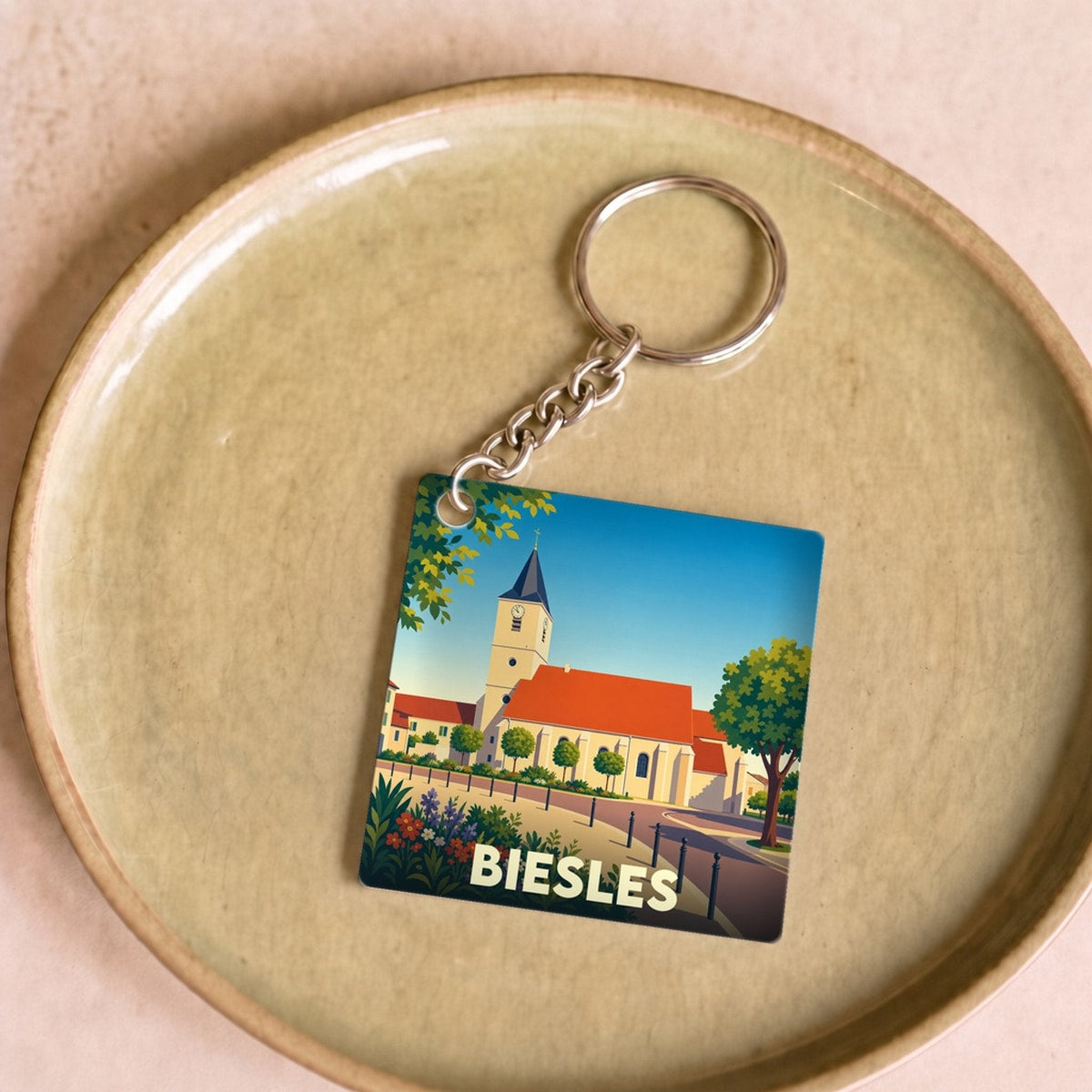 Porte-clés souvenir de la ville de Biesles avec une illustration stylisée de son église.