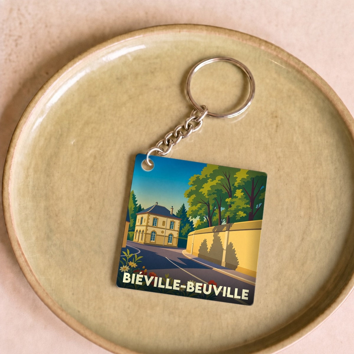 Porte-clés souvenir de la ville de Biéville-Beuville avec une illustration stylisée.