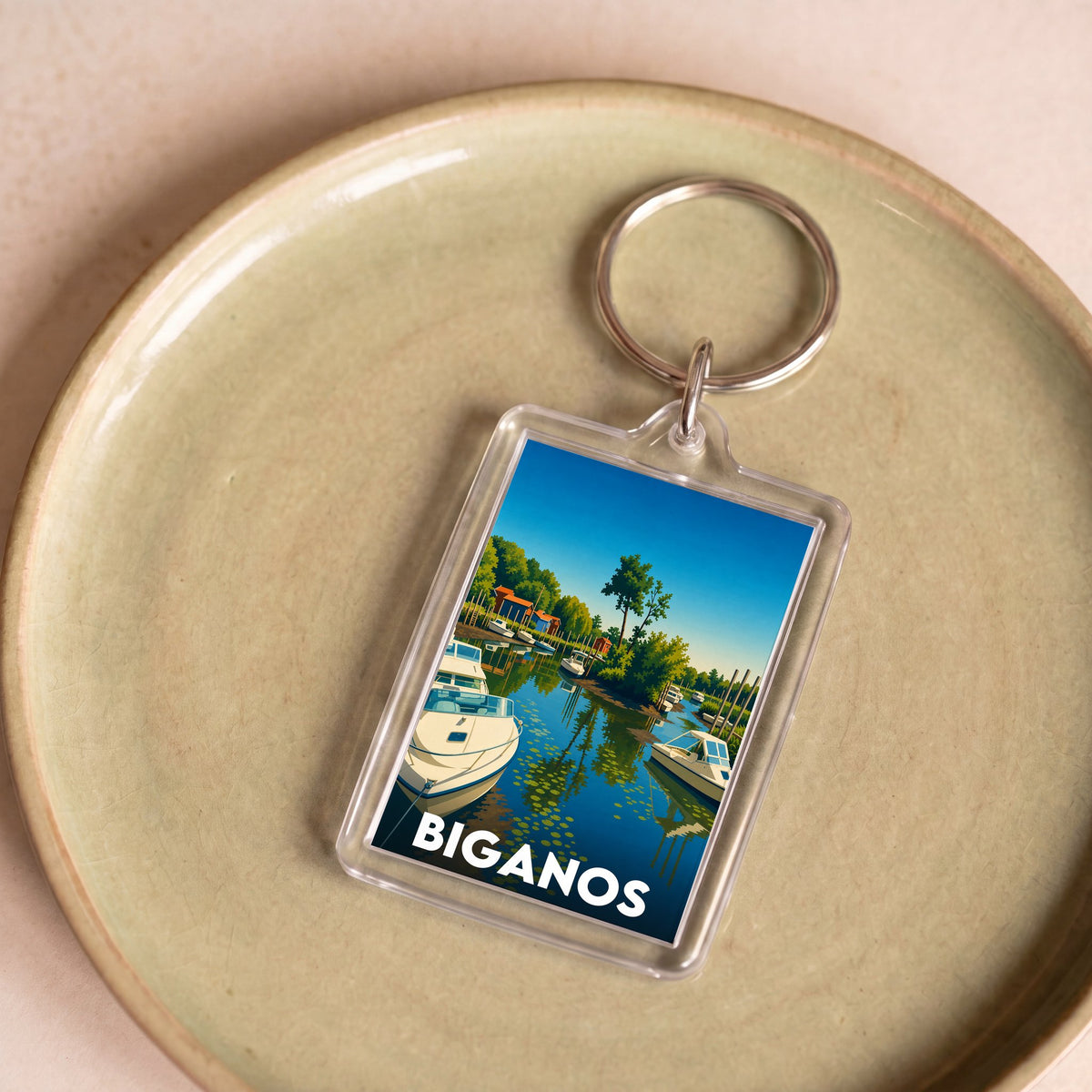 Porte-clés souvenir de la ville de Biganos avec une illustration stylisée d'un port de plaisance.