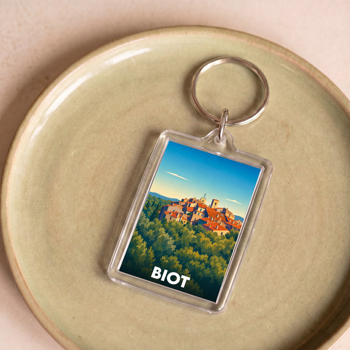 Porte-clés souvenir de la ville de Biot orné d'une illustration stylisée du village perché.