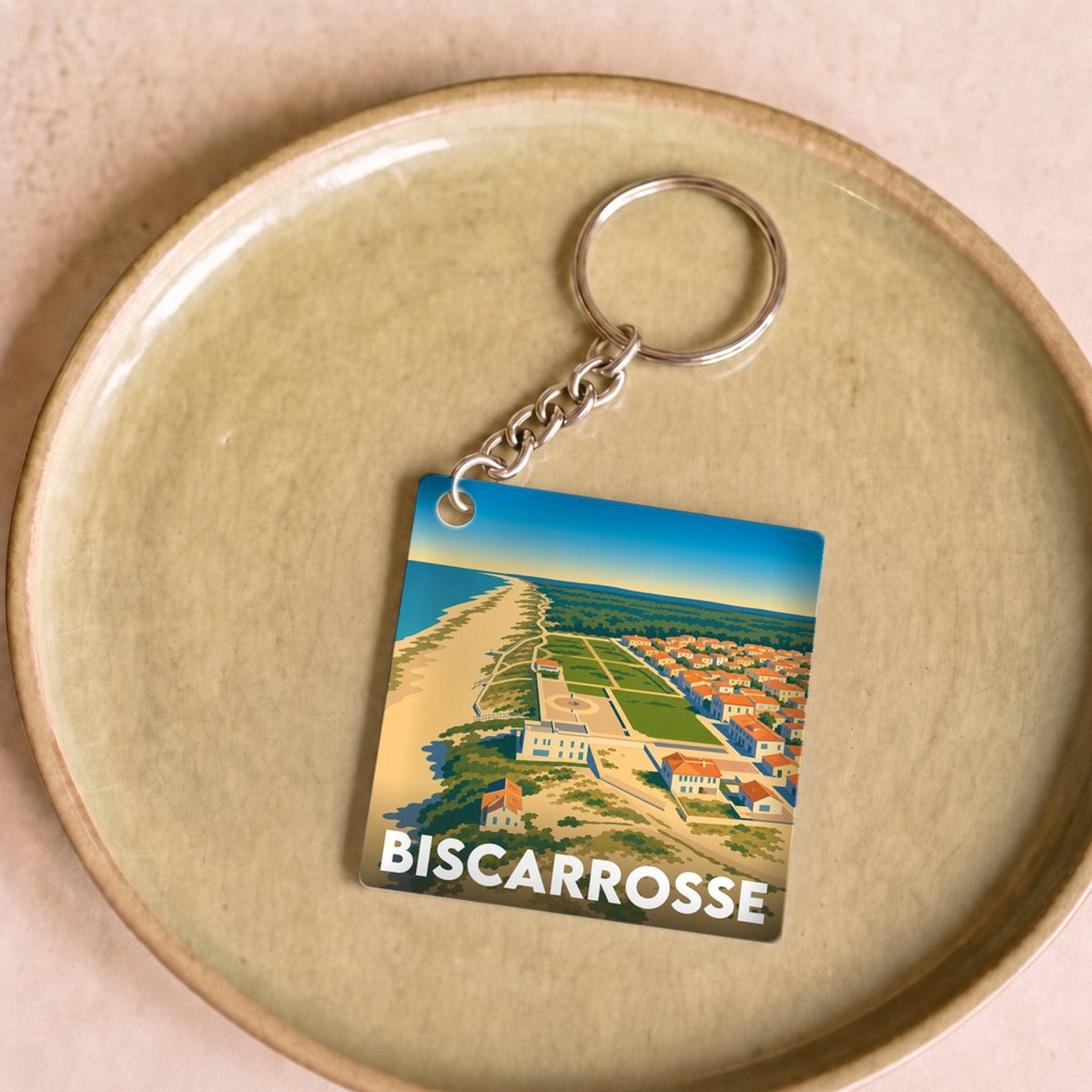 Porte-clés souvenir de la ville de Biscarrosse avec une illustration stylisée de son littoral.