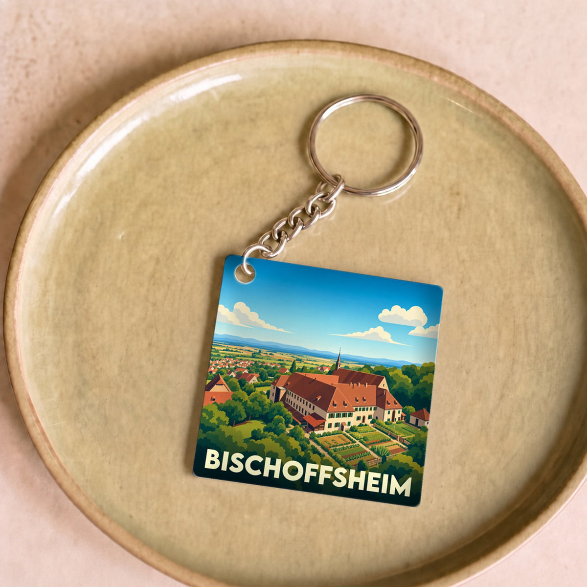 Porte-clés souvenir de la ville de Bischoffsheim avec une illustration stylisée.