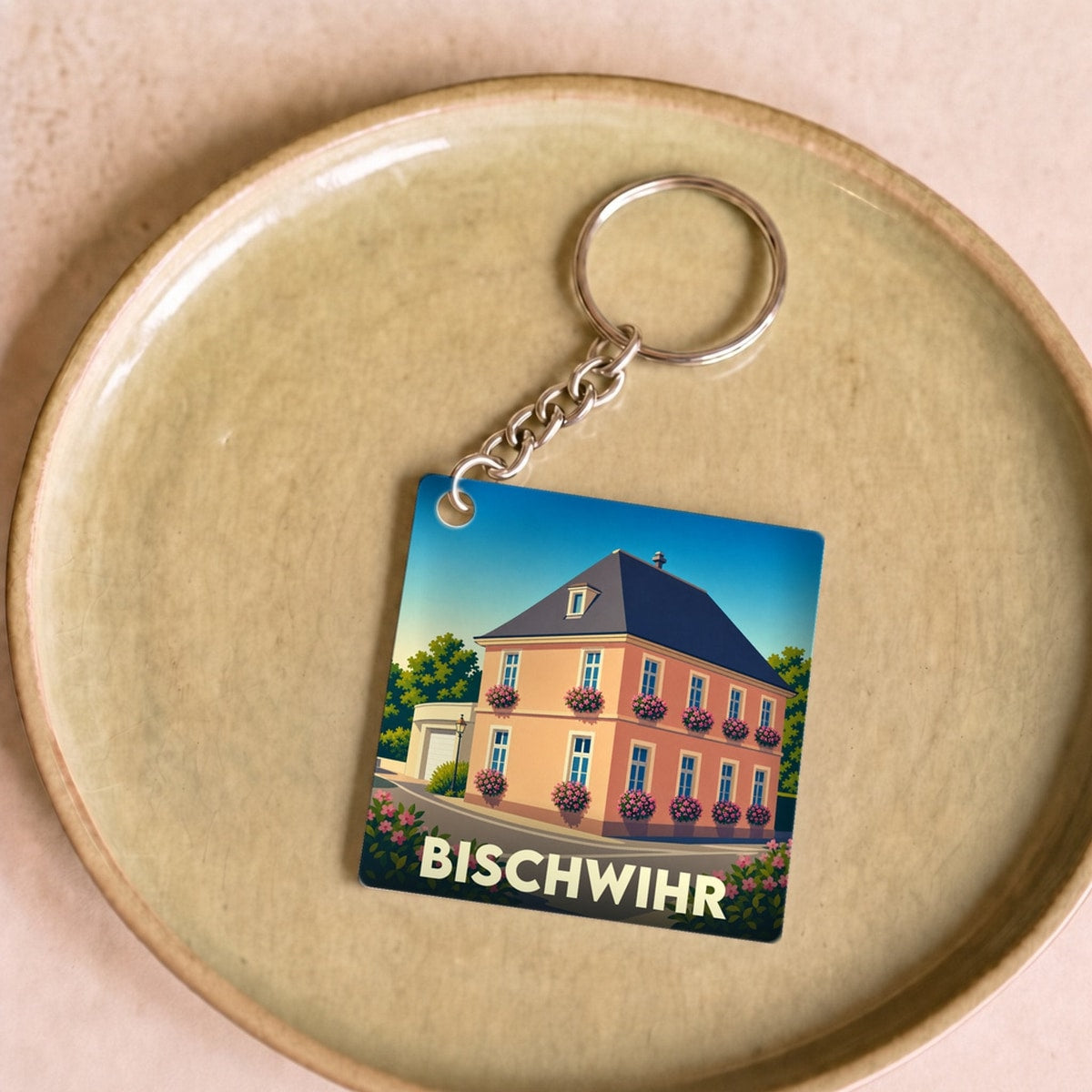 Porte-clés souvenir de la ville de Bischwihr avec une illustration stylisée d'une maison fleurie.