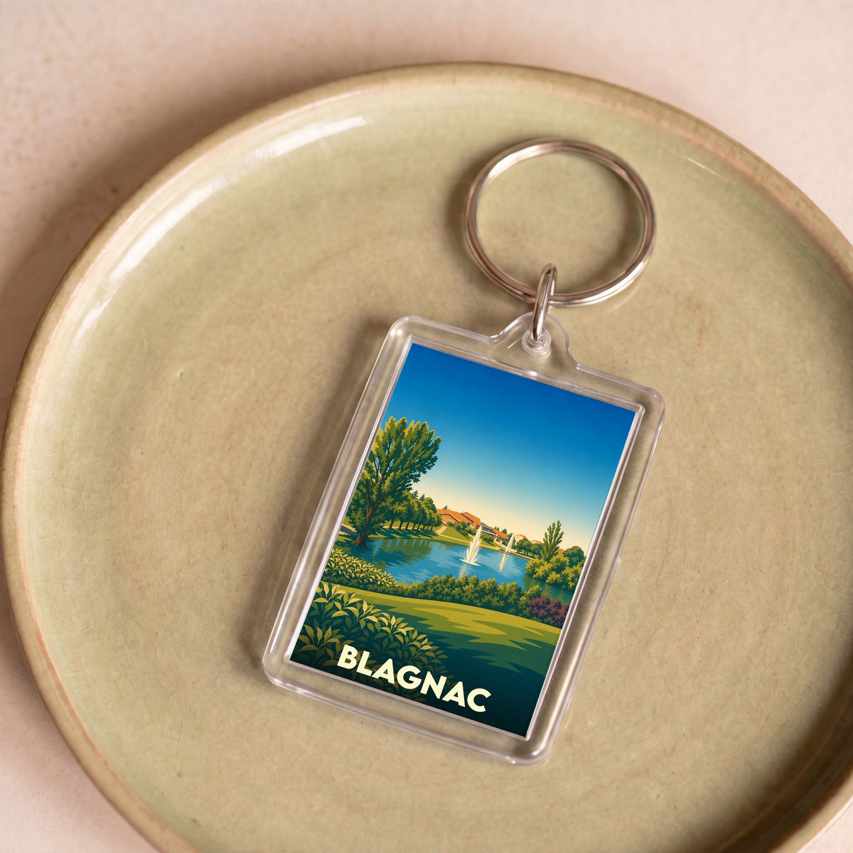 Porte-clés souvenir de la ville de Blagnac avec une illustration stylisée d'un parc paysager.
