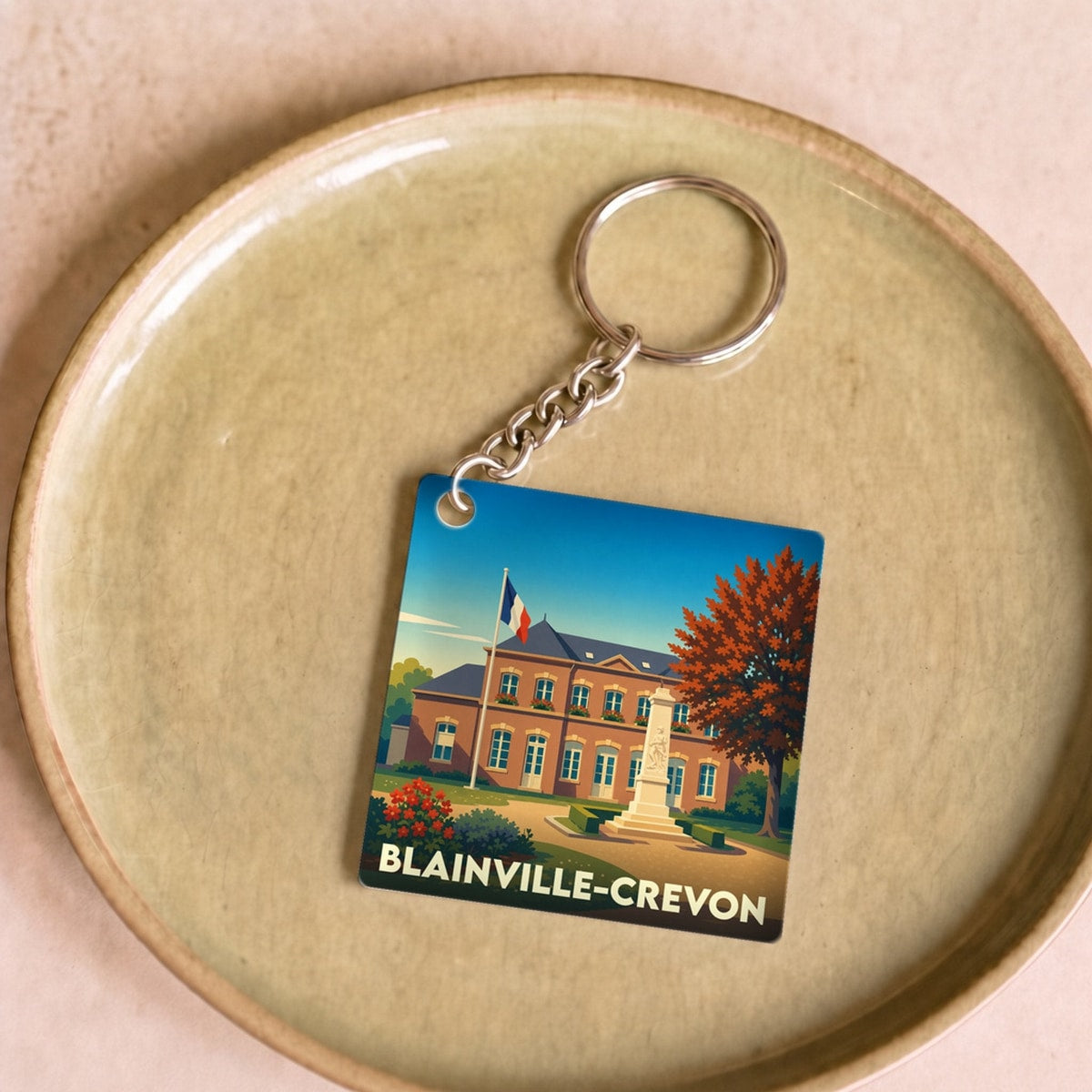 Porte-clés souvenir de la ville de Blainville-Crevon avec une illustration stylisée de sa mairie.