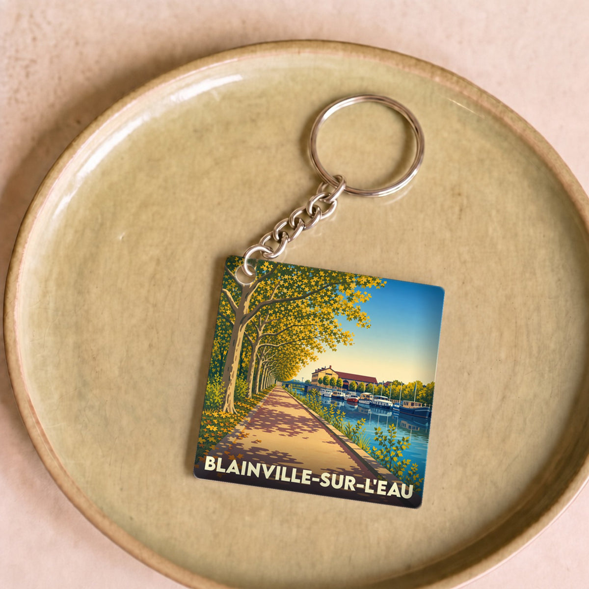 Porte-clés souvenir de la ville de Blainville-sur-l'Eau avec une illustration stylisée.