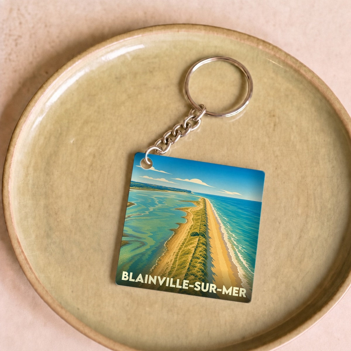 Porte-clés souvenir de la ville de Blainville-sur-Mer avec une illustration stylisée de son littoral.