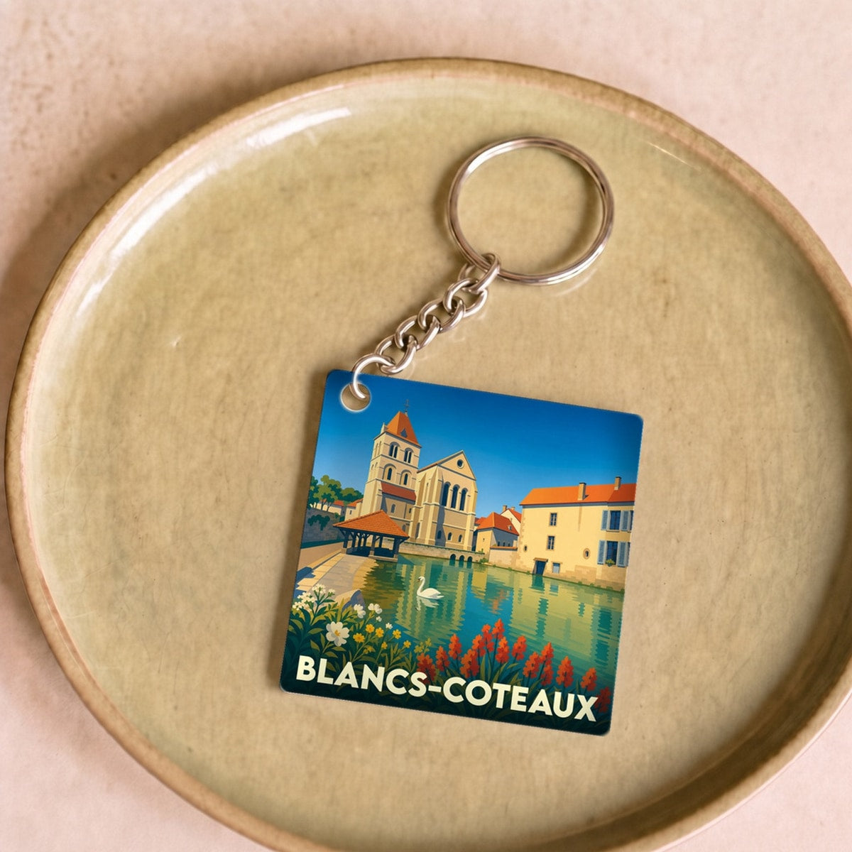 Porte-clés souvenir de la ville de Blancs-Coteaux avec une illustration stylisée.