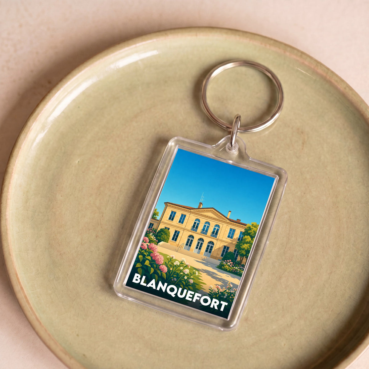 Porte-clés souvenir de la ville de Blanquefort avec une illustration stylisée.