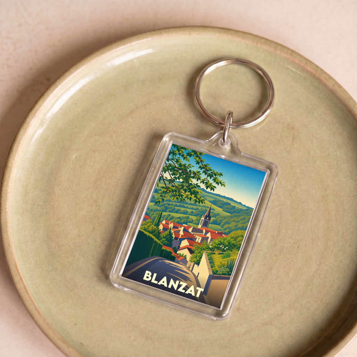 Porte-clés souvenir de la ville de Blanzat avec une illustration stylisée.