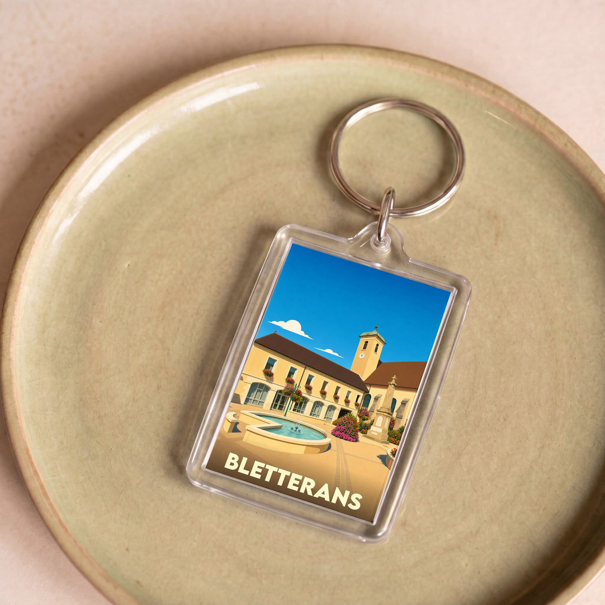 Porte-clés souvenir de la ville de Bletterans avec une illustration stylisée.