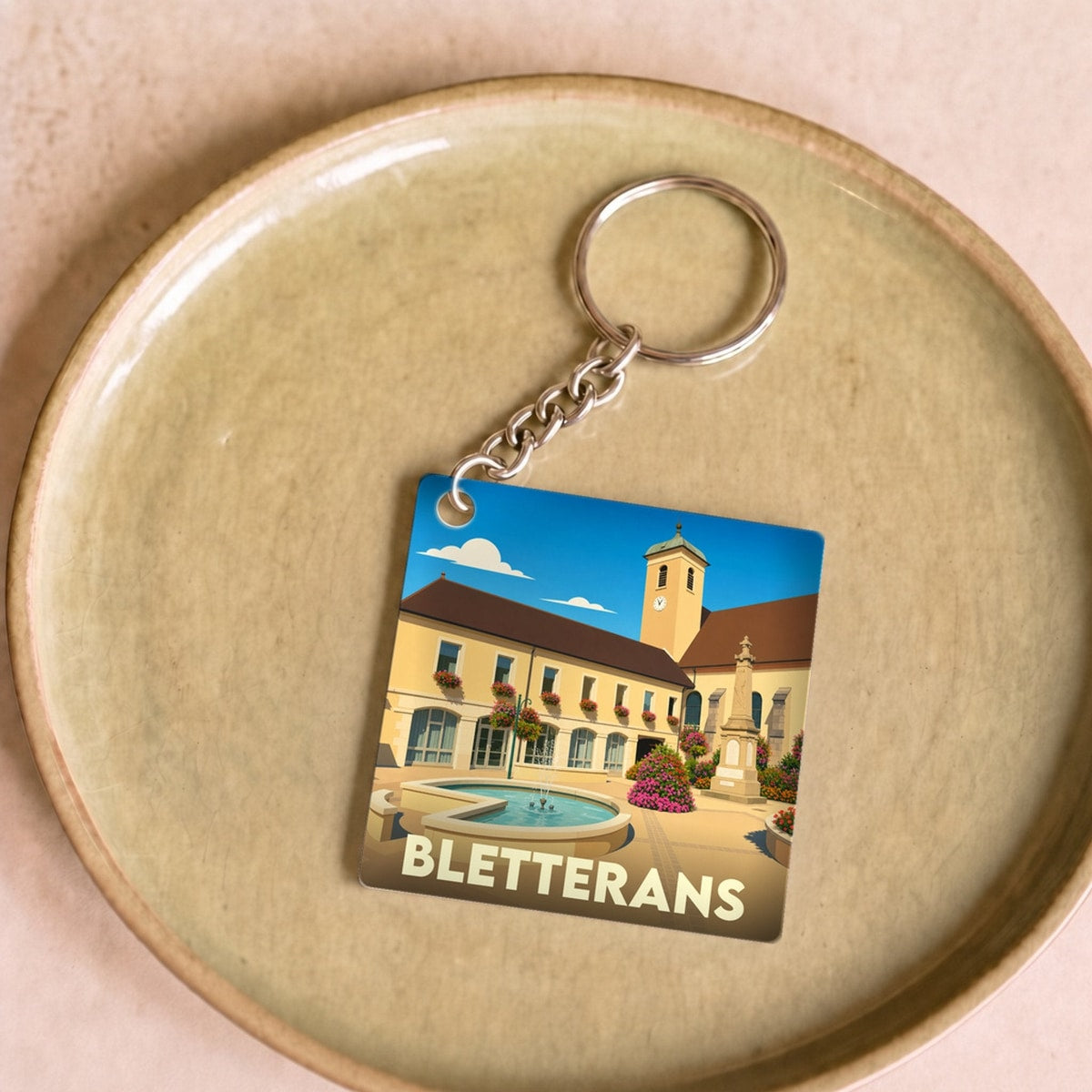 Porte-clés souvenir de la ville de Bletterans avec une illustration stylisée.