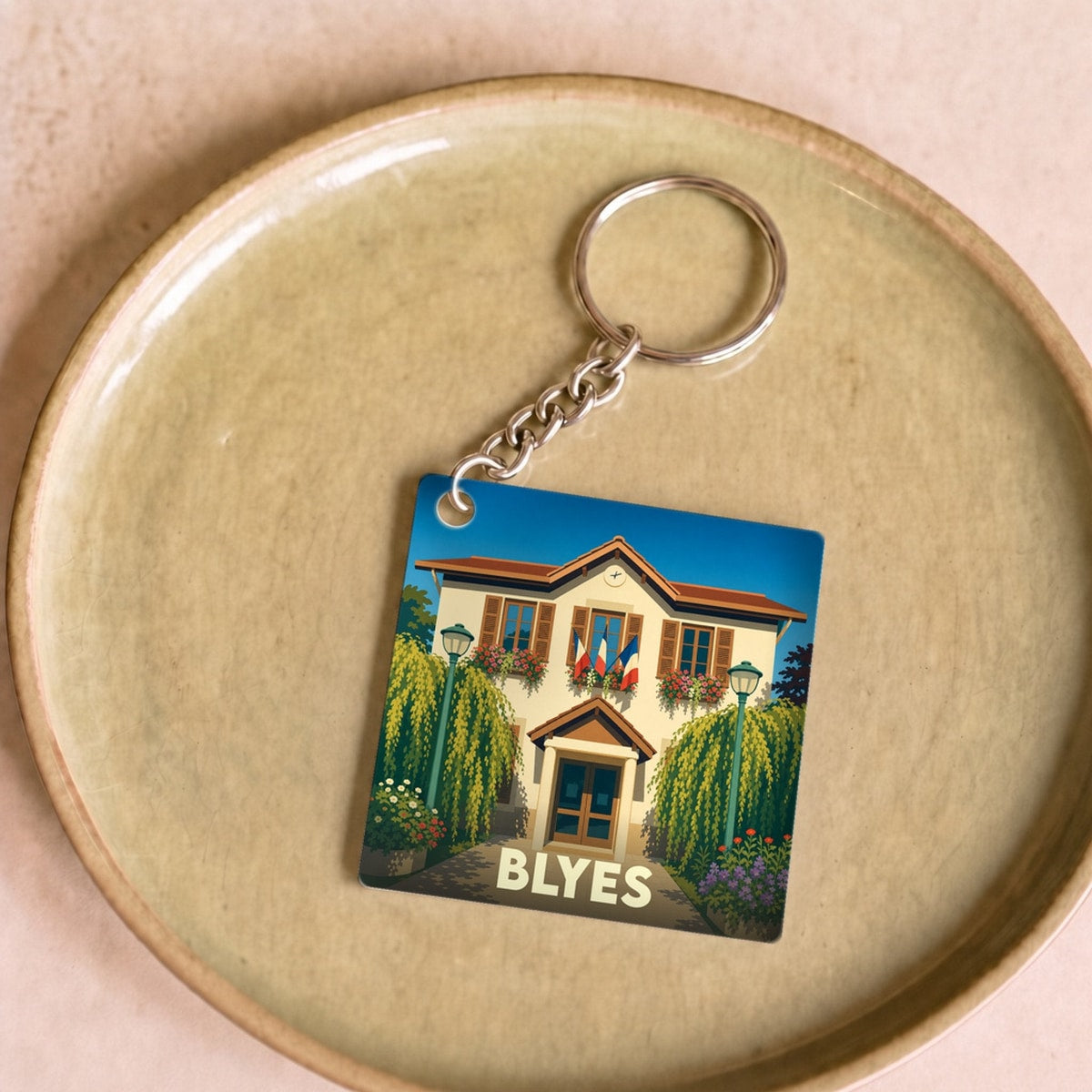 Porte-clés souvenir de la ville de Blyes avec une illustration stylisée de sa mairie.