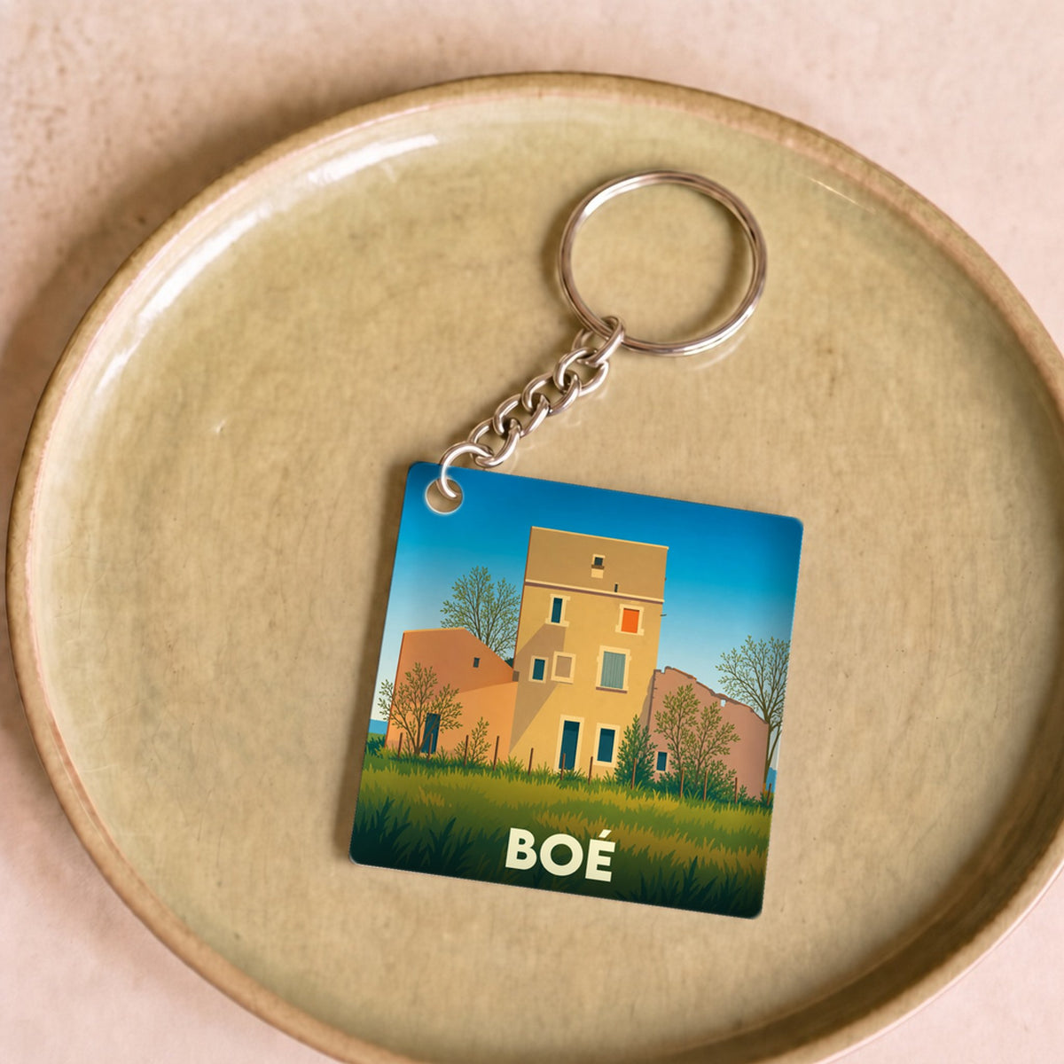 Porte-clés souvenir de la ville de Boé avec une illustration stylisée de maisons colorées.