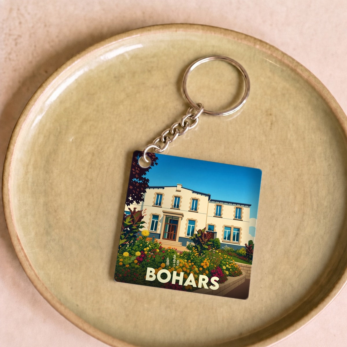Porte-clés souvenir de la ville de Bohars avec une illustration stylisée de sa mairie fleurie.