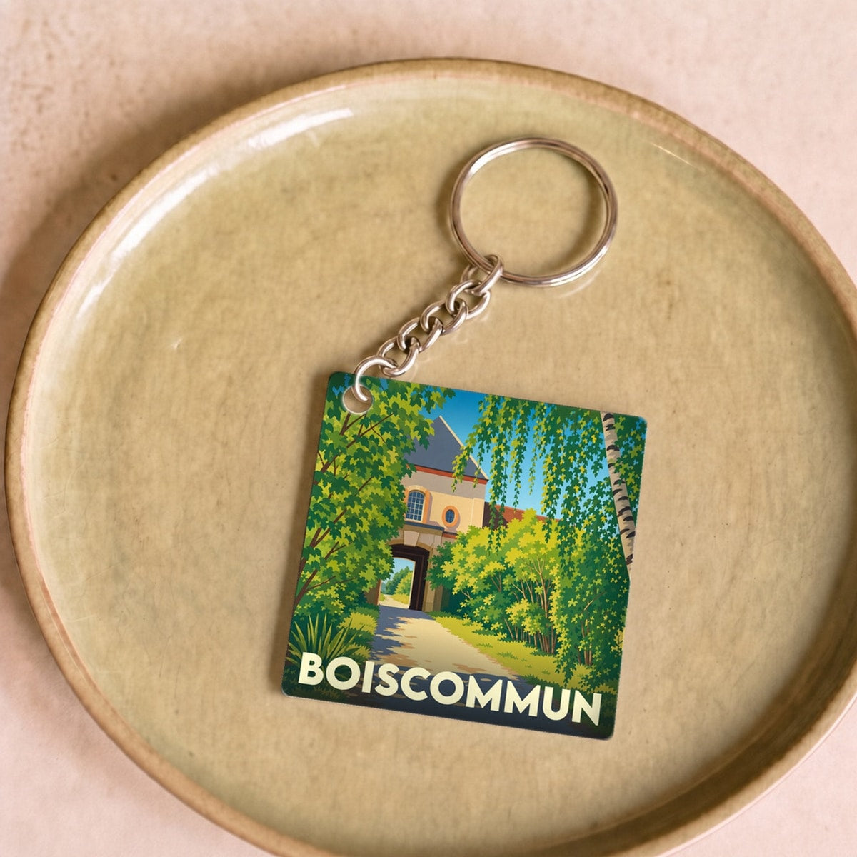 Porte-clés souvenir de la ville de Boiscommun avec une illustration stylisée.