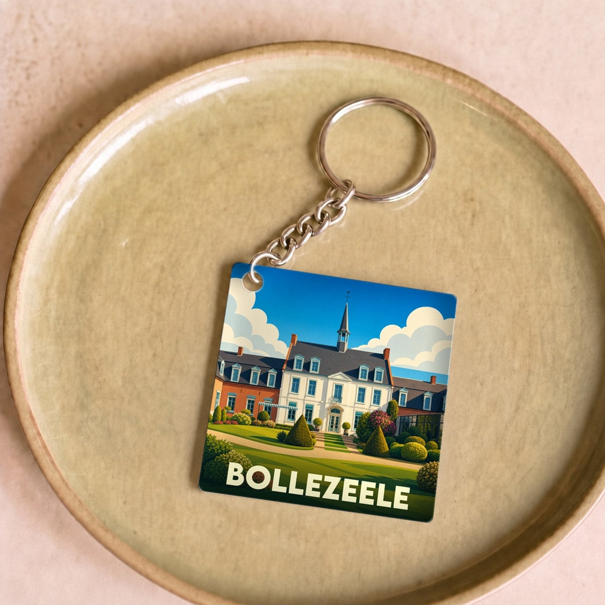 Porte-clés souvenir de la ville de Bollezeele avec une illustration stylisée.