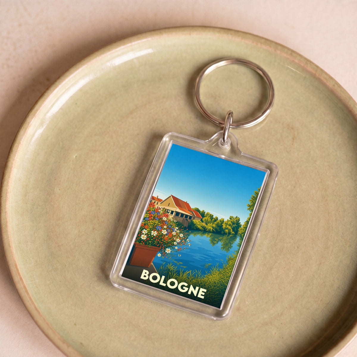 Porte-clés souvenir de la ville de Bologne avec une illustration stylisée d'un paysage au bord de l'eau.