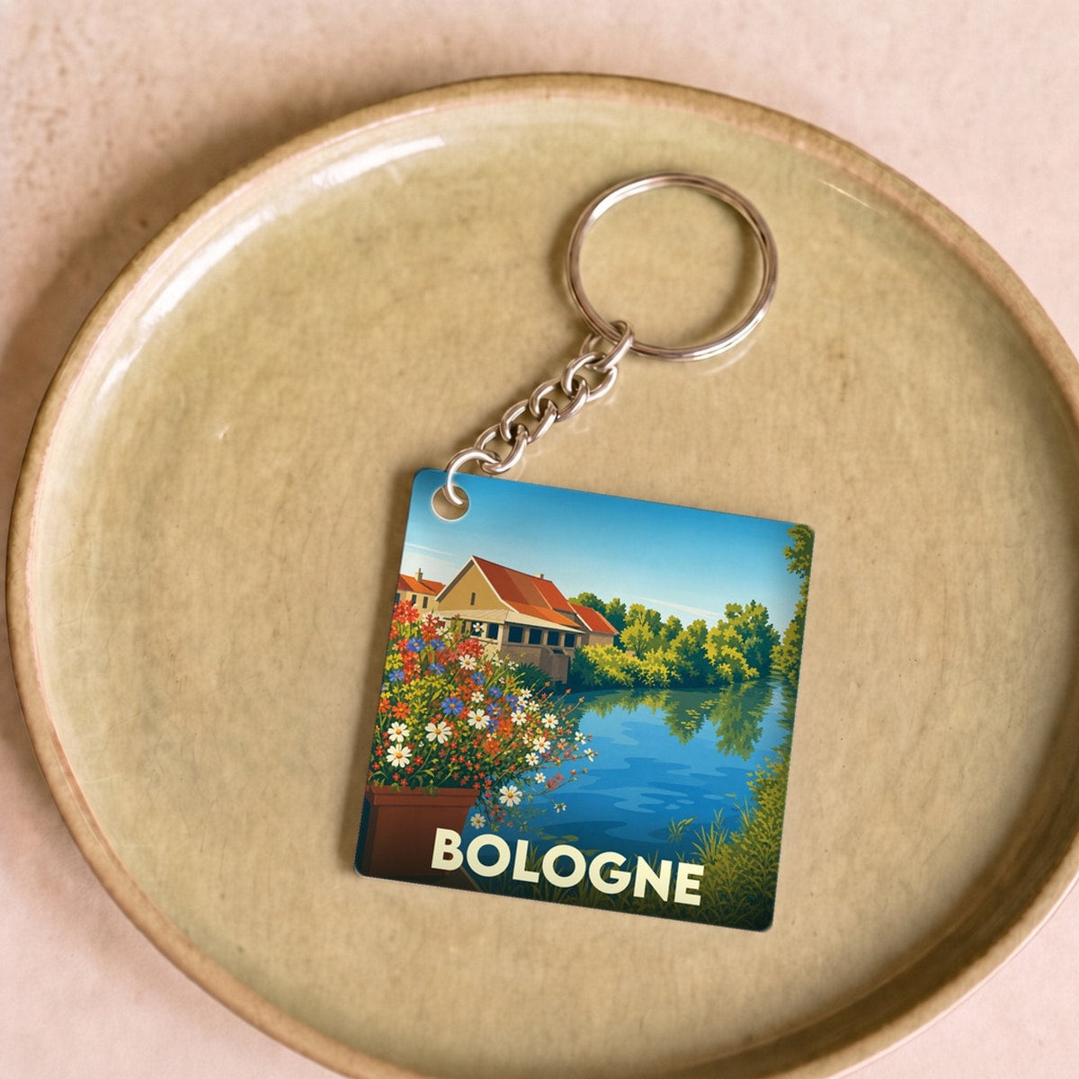 Porte-clés souvenir de la ville de Bologne avec une illustration stylisée d'un paysage au bord de l'eau.