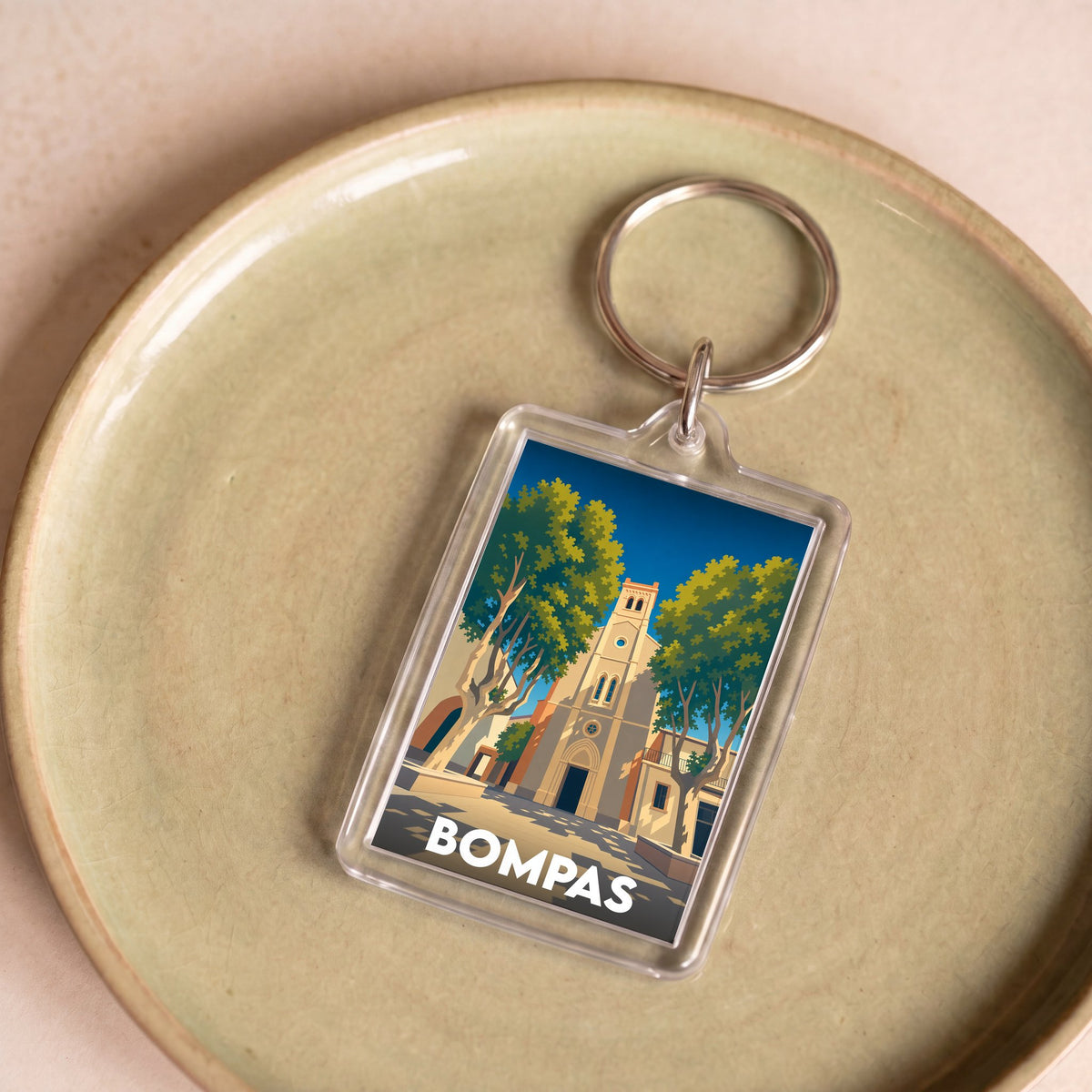 Porte-clés souvenir de la ville de Bompas avec une illustration stylisée.