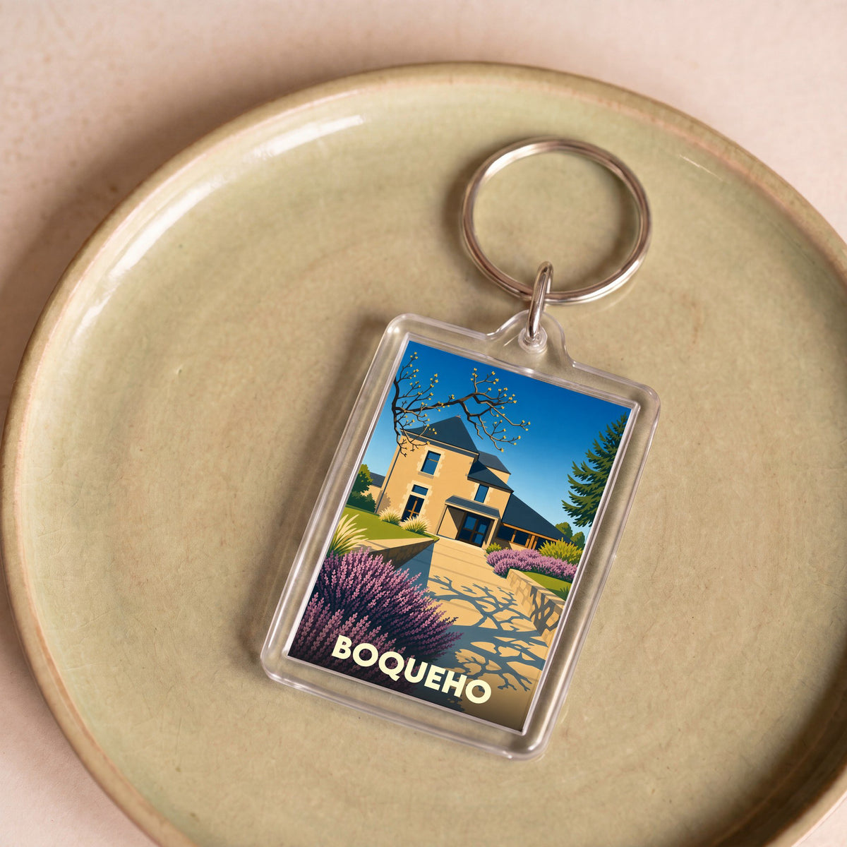 Porte-clés souvenir de la ville de Boqueho avec une illustration stylisée d'une maison bretonne.