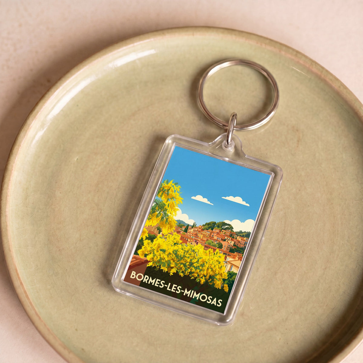 Porte-clés souvenir de la ville de Bormes-les-Mimosas avec une illustration stylisée.