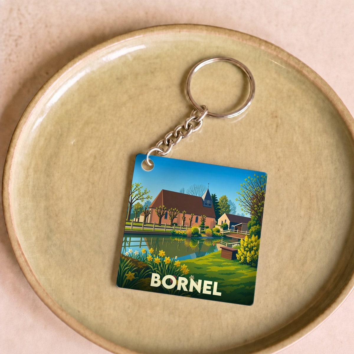 Porte-clés souvenir de la ville de Bornel avec une illustration stylisée et colorée.