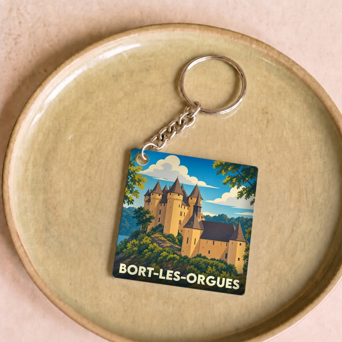 Porte-clés souvenir de la ville de Bort-les-Orgues avec une illustration stylisée de son château.