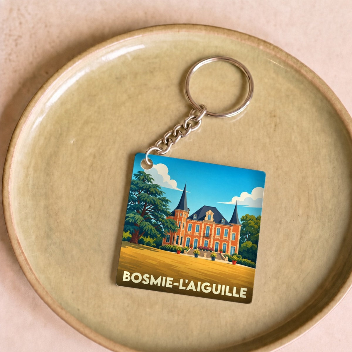 Porte-clés souvenir de la ville de Bosmie-l'Aiguille avec une illustration stylisée de son château.
