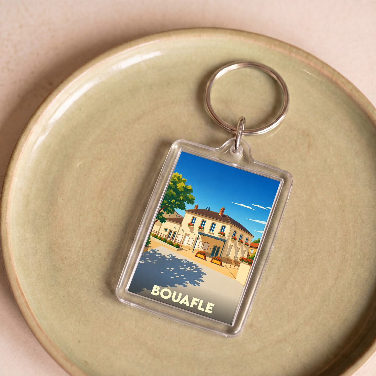 Porte-clés souvenir de la ville de Bouafle avec une illustration stylisée.