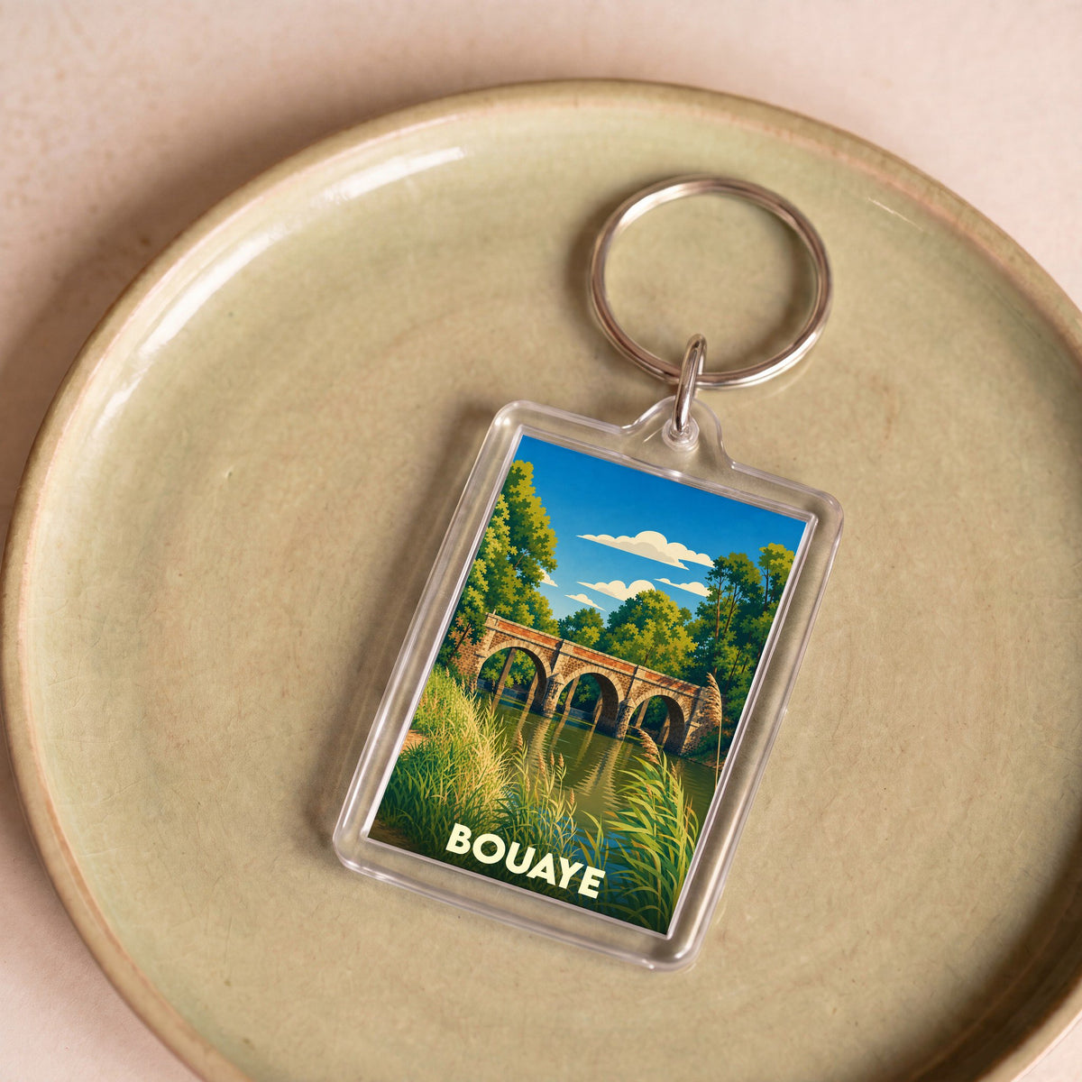Porte-clés souvenir de la ville de Bouaye avec une illustration stylisée d'un pont en pierre.