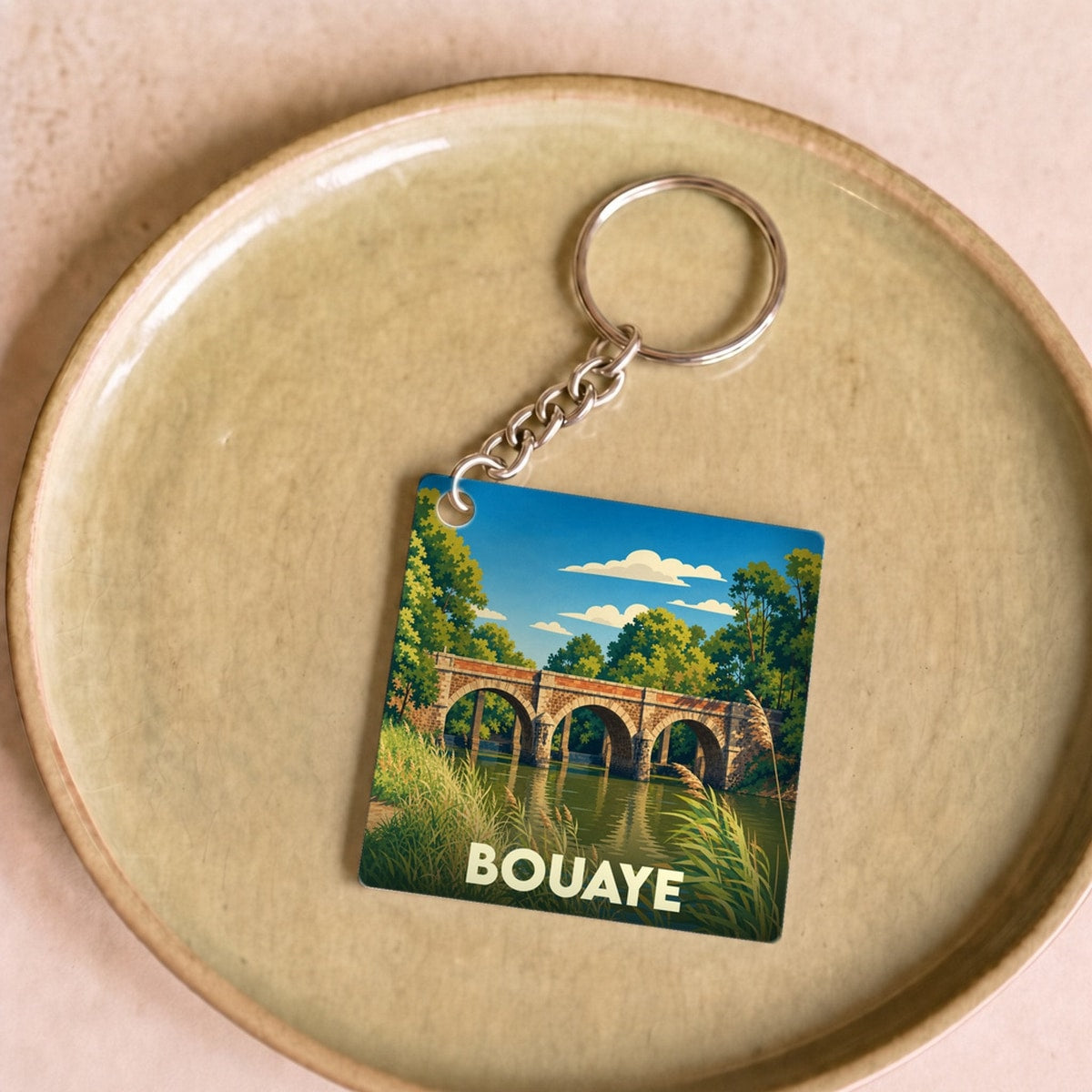 Porte-clés souvenir de la ville de Bouaye avec une illustration stylisée d'un pont en pierre.