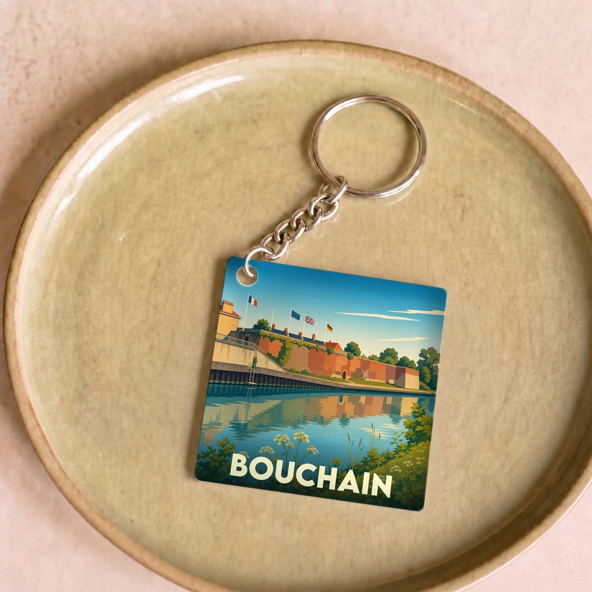Porte-clés souvenir de la ville de Bouchain avec une illustration stylisée représentant ses fortifications au bord de l'eau.
