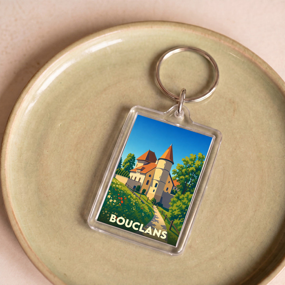 Porte-clés souvenir de la ville de Bouclans avec une illustration stylisée d'un château.