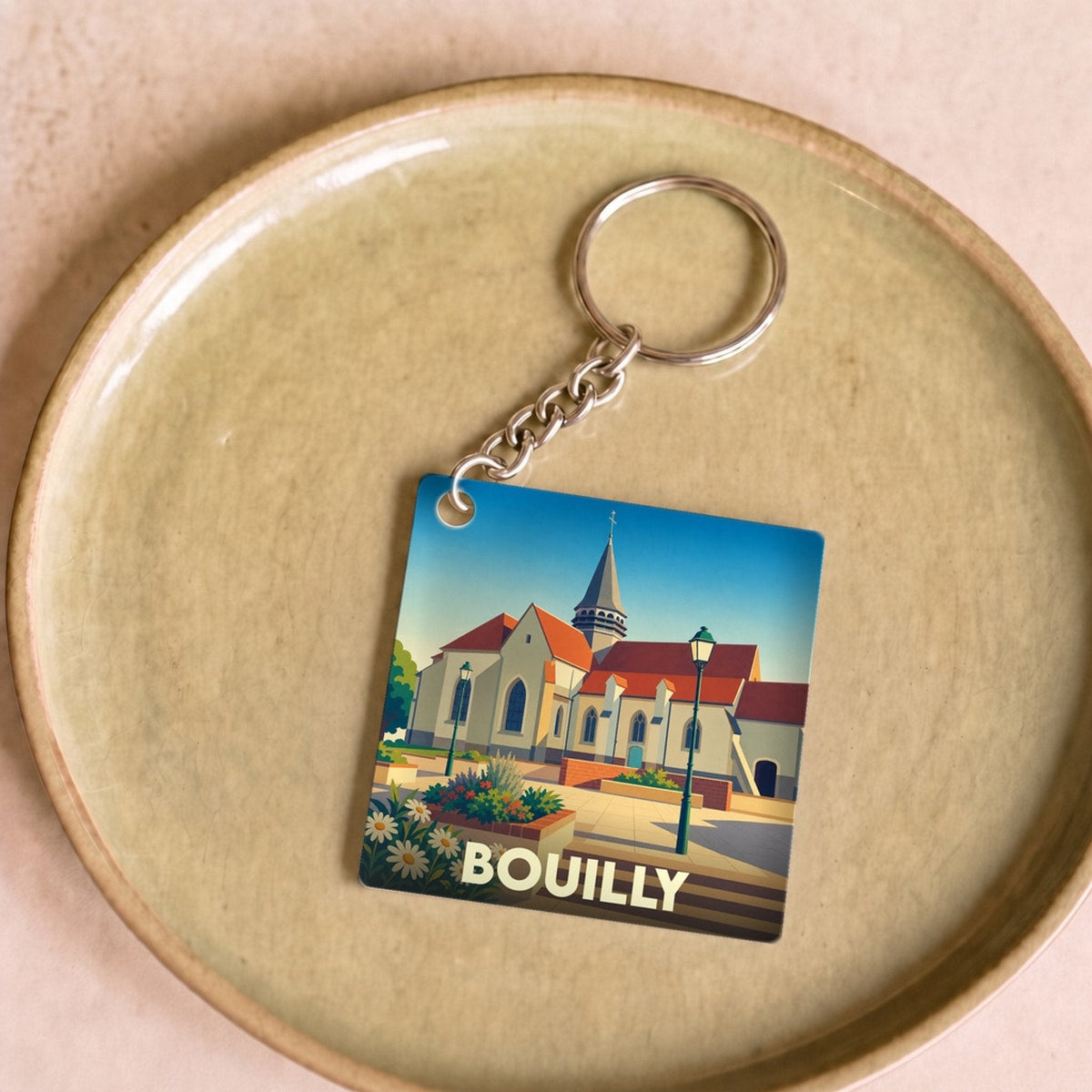 Porte-clés souvenir de la ville de Bouilly avec une illustration stylisée de son église.