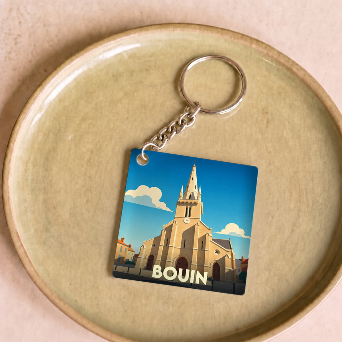 Porte-clés souvenir de la ville de Bouin avec une illustration stylisée de son église.