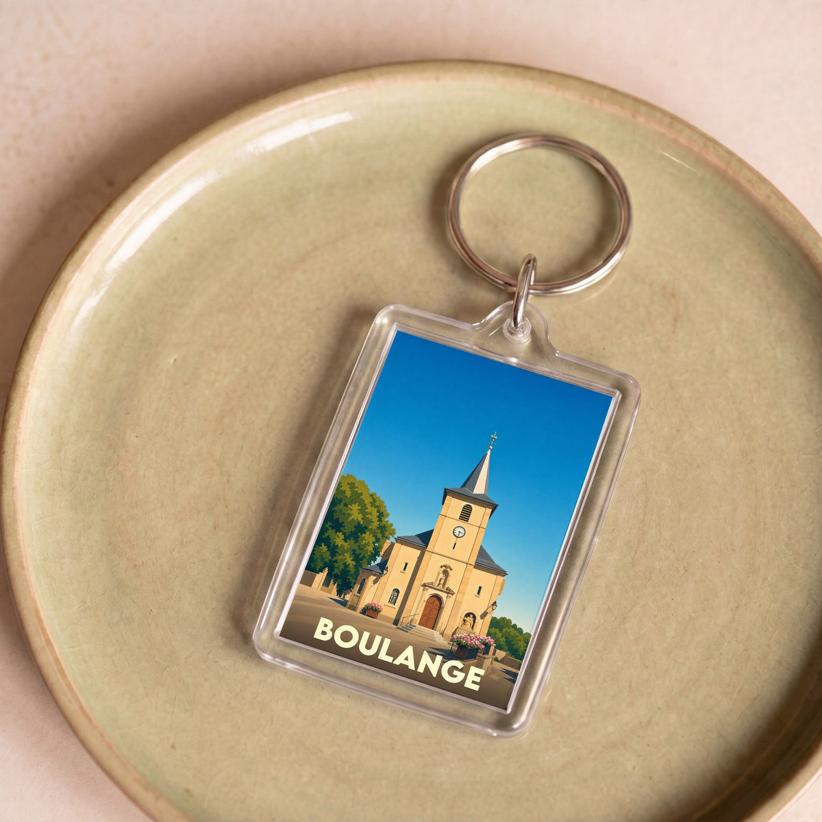 Porte-clés souvenir de la ville de Boulange avec une illustration stylisée de son église.