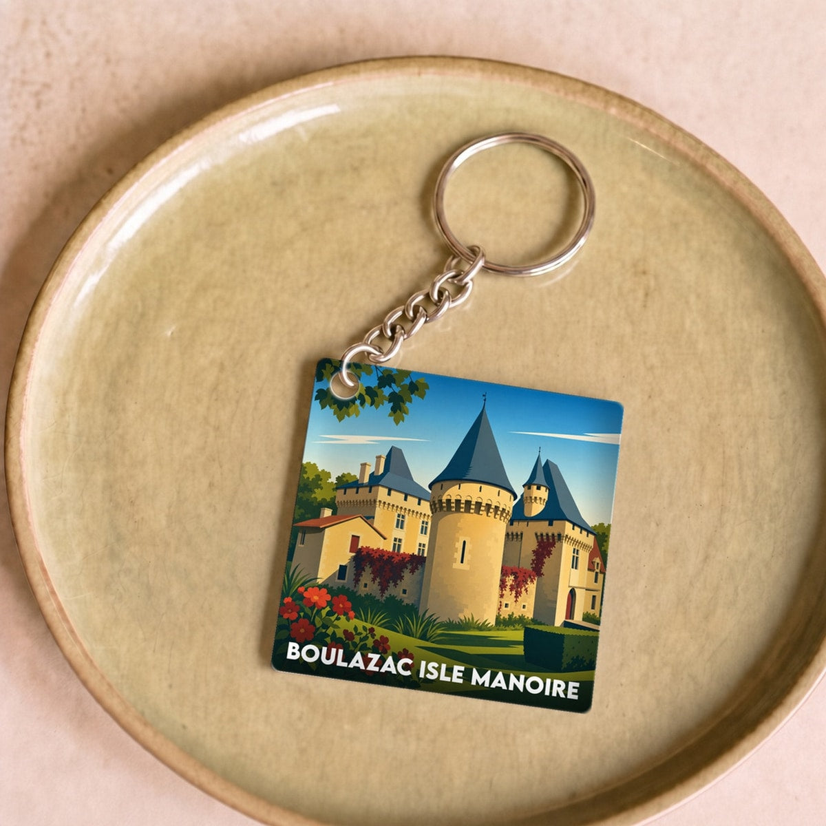 Porte-clés souvenir de la ville de Boulazac Isle Manoire avec une illustration stylisée d'un château.