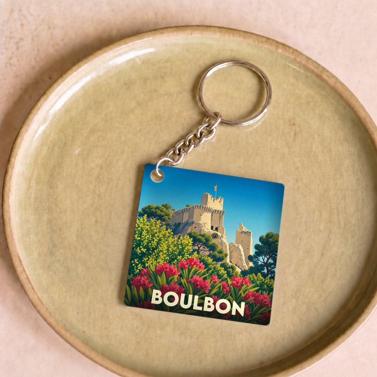 Porte-clés souvenir de la ville de Boulbon avec une illustration stylisée de son château médiéval.