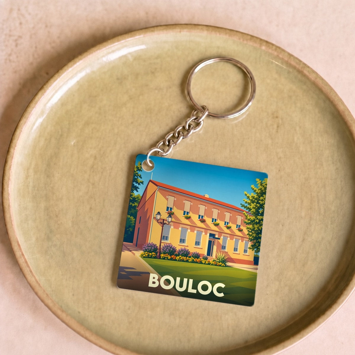 Porte-clés souvenir de la ville de Bouloc avec une illustration stylisée.