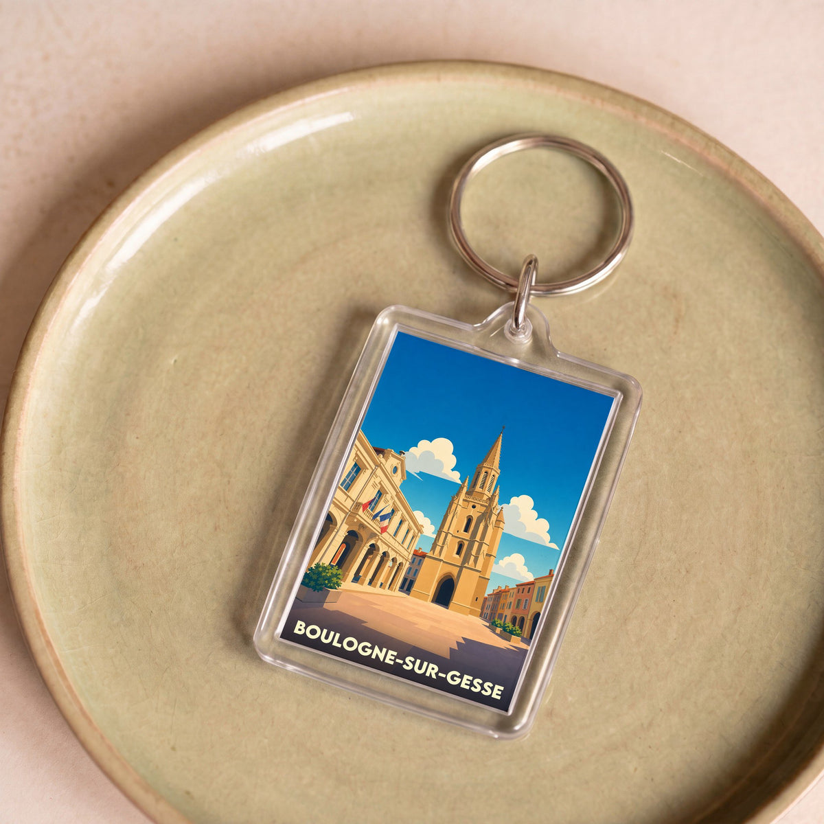 Porte-clés souvenir de la ville de Boulogne-sur-Gesse avec une illustration stylisée.