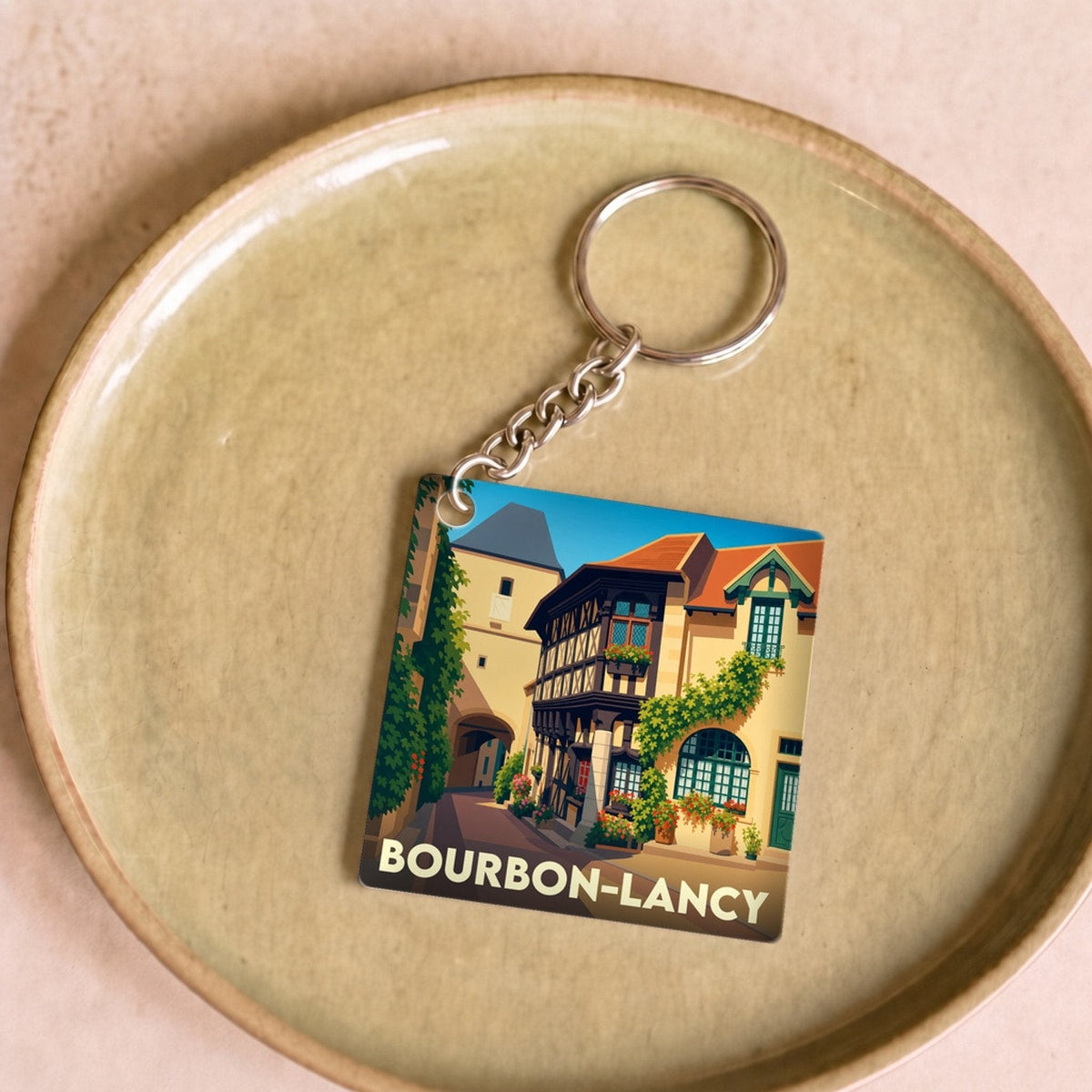 Porte-clés souvenir de la ville de Bourbon-Lancy avec une illustration stylisée de ses maisons à colombages.