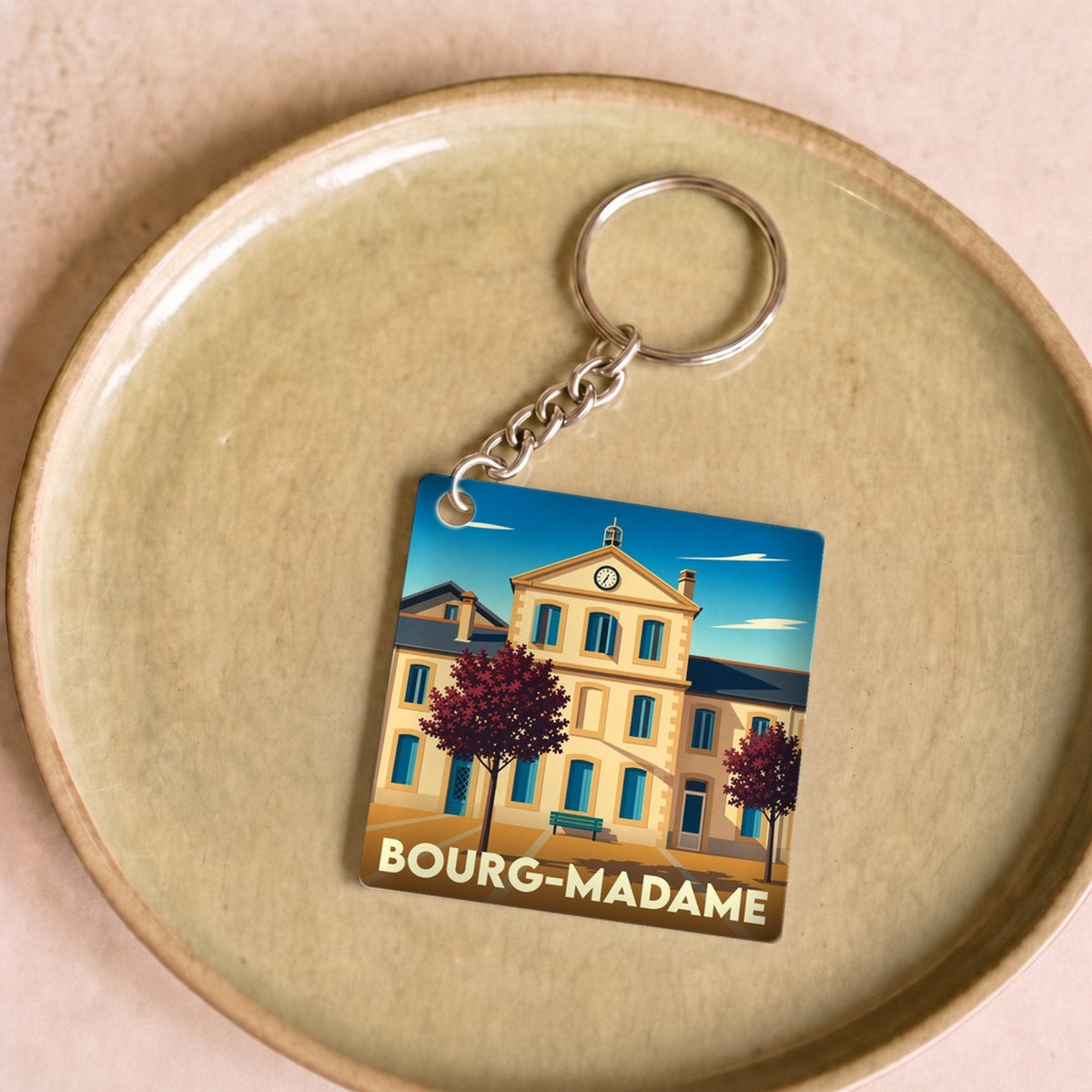 Porte-clés souvenir de la ville de Bourg-Madame avec une illustration stylisée.